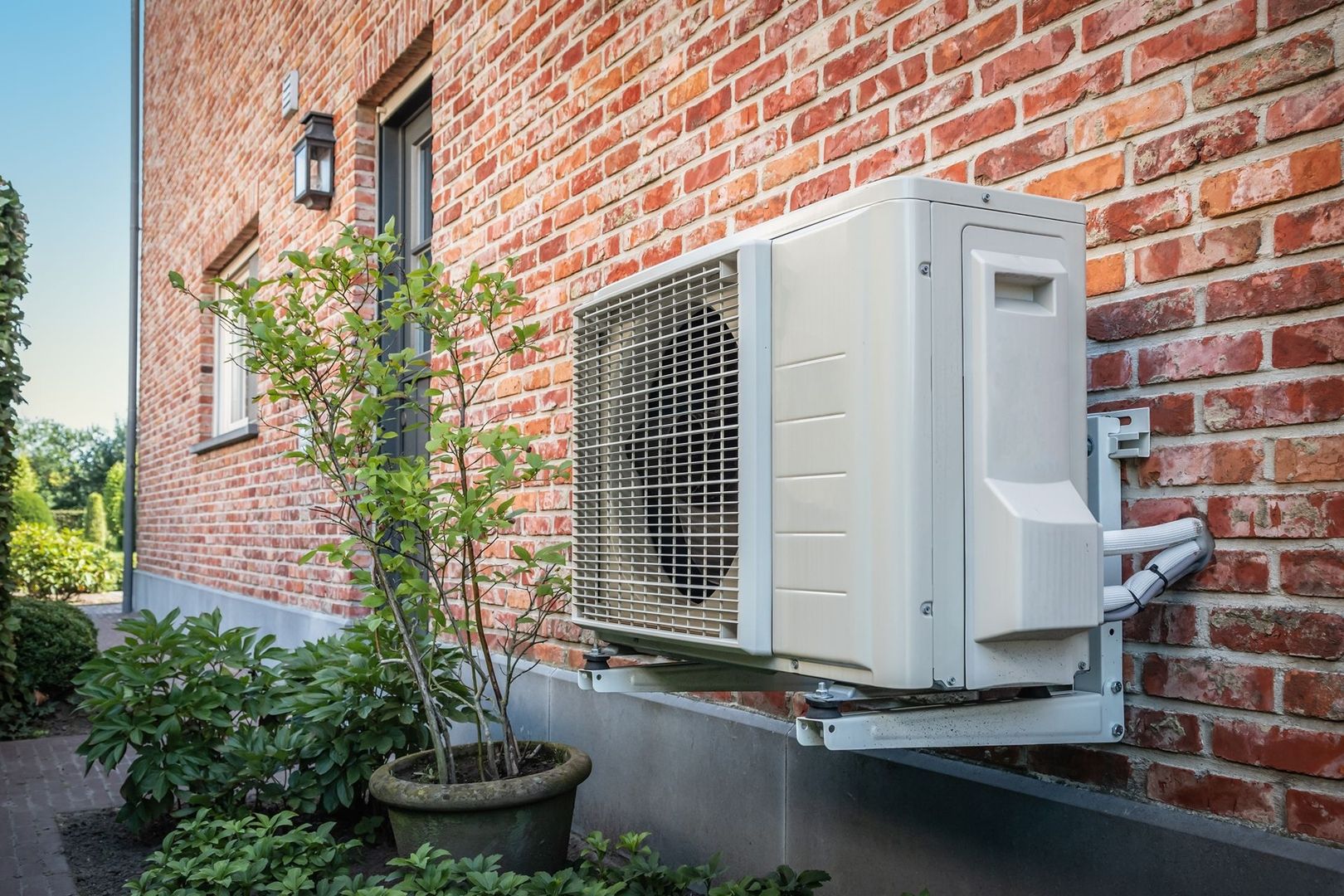 Wärmepumpen-Außengerät an der Backsteinfassade eines Altbaus – Wärmepumpe im Altbau in Mühldorf